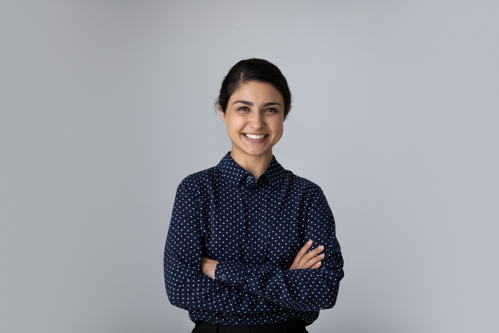 Head shot portrait smiling Indian woman with arms crossed